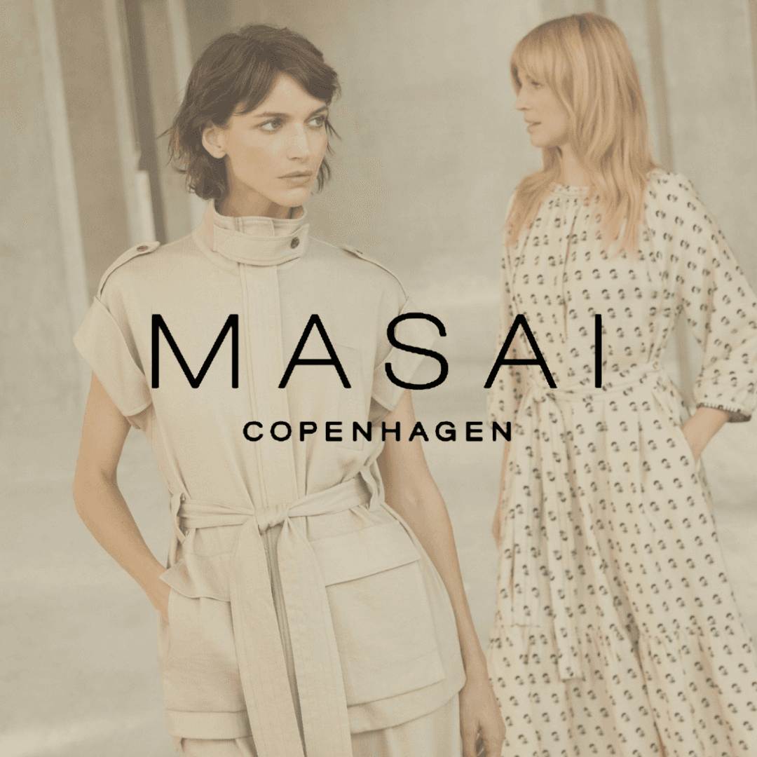 Two women in neutral-toned outfits, one in a belted jumpsuit and the other in a patterned dress, with "MASAI Copenhagen" text overlay.