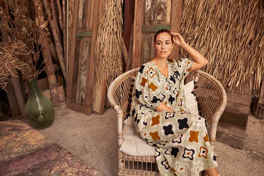 Kvinde sidder i stol med pileflet