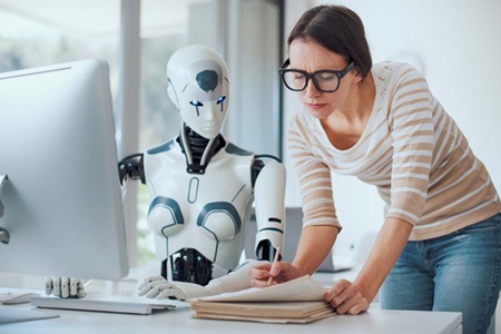 En robot og et menneske samarbejder ved en kontorplads