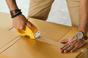 A person puts tape on a box